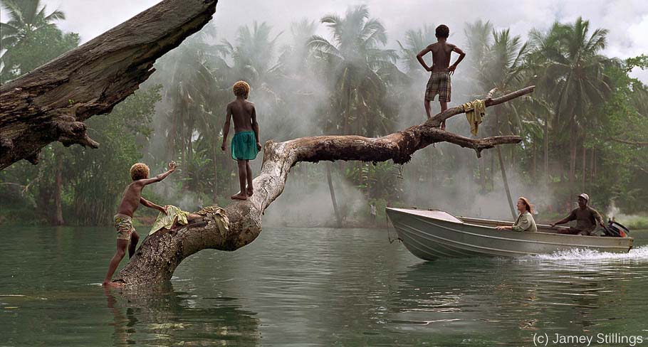 Boat on river with children in jungle (c) Jamey Stillings