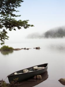 Boat in misty lake.