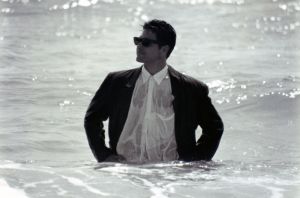 Man with wet suit in sea.